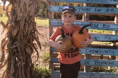 Boy-with-two-pumpkins-by-sign