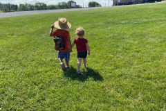 Two-young-children-walking-up-to-dairy-barn